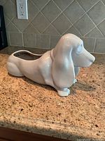 Full side view of the ceramic dog planter showing its long body and planter opening on the back.