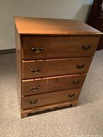 Full front view of the high boy dresser showing five drawers and metal handles.