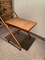 Vintage folding rolling tray service set up with tray surface and wooden folding frame.