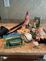 Group shot of all items included in the lot arranged on a countertop including figurines, bus, piggy bank, and walking sticks.