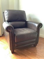 Front view of dark brown leather occasional chair showing rolled arms and cushioned seat
