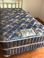 Twin size mattress and box spring with blue floral pattern and cream piping. Mattress label visible.