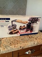 Photo of front side of original Sunbeam toaster box showing 4 slice toaster with waffles and berries.
