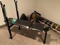 Full view of York 110 bench with uprights and leg attachment, loaded bars and plates on floor