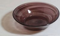 Top angled view showing the purple swirl pattern inside the round glass bowl with flared rim.