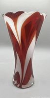 Full front view of red and white swirled hand blown glass vase with scalloped rim