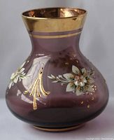 Front and side views of the purple glass vase with gold rim, floral, and gold detailing.