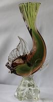 Side profile of the large Murano glass fish sculpture showing its coloration and textured base.