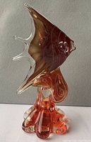 Side view of Murano glass fish on ornate base showing red to brown gradient and clear glass fins
