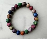 Top-down view of the multicolor natural stone bead bracelet showing the full circle of beads and their varied colors and textures.