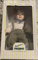 Front of boxed clown doll showing doll inside clear window box.