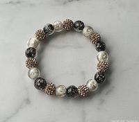 Image showing the entire crackled glass and rhinestone bead bracelet on a neutral background to highlight details.