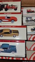 Close-up of various collectible car boxes showing model names like 1914 Knox-Martin, 1957 Corvette, 1969 Oldsmobile 442, Chevrolet Bel Air.