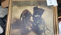 Framed print on board showing a pair of old leather shoes with laces worn and aged, signed 'Vincent' in red ink at upper left corner