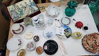 Photo showing all items laid out on a surface including silk print box, green vase, ceramic basket, trinket boxes, tea cup and saucer, and various decorative trinkets.