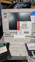 Toshiba Satellite Pro T2449CT laptop front view with keyboard, screen, floppy disk, and configuration CD visible