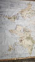 Full view of large world map on canvas with visible continents and ocean names.