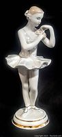 Full front view of the antique porcelain ballerina figurine standing on its base, showcasing hand painted details and delicate posture.