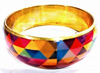 Clear image of the vintage brass enamel geometric bangle showing colorful triangular pattern and gold interior.