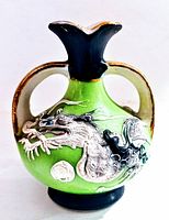Photo of front side of miniature Satsuma Japanese vase showing detailed hand painted dragon and double handles on bright green body with black neck and base