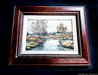 Framed vintage signed original oil on board landscape painting showing river with trees and hills, in detailed medium brown ornate wooden frame.