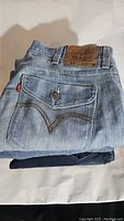 Folded pair of Levi's women's jeans showing leather patch with size and pocket details in light blue wash