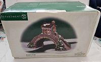 Closed box showing the Department 56 Abington Bridge branding and image of the figurine, with some wear on box edges.