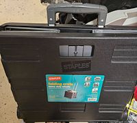 Top view showing the Staples label, product details, and handle on the crate lid.