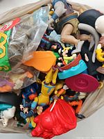Close up of assorted Disney toys and figures piled together, showing a mix of characters and toy parts.