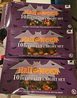 Photo of three boxes for Halloween 10 light indoor/outdoor decorative light sets in purple packaging with bats and ghosts graphics.