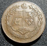 Back side of the medallion showing the detailed Canadian coat of arms surrounded by maple leaves and a crown