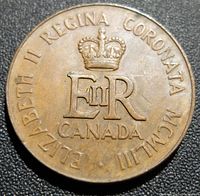Close-up front side of the medallion showing crowned ER monogram, Canada, and Latin inscription around.