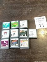 Top view of 10 Nintendo DS game cartridges arranged in grid showing titles and labels with varied game names and ESRB ratings.