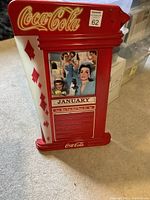 Front view of the Coca-Cola red perpetual calendar with a vintage image and January monthly display.
