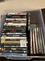 Container with 31 DVDs stacked inside, titles visible include The Bye Bye Man, The Village, Insidious, Saw, The Wolfman, Dragon Warrior, Underworld among others.