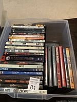 Photo showing a container with 31 DVDs stacked horizontally and vertically. Visible titles include Saw II, Gothika, Legion, Grind, I Am Sam, Due Date, Harry Potter and the Prisoner of Azkaban, Troy, Falling Down, Edmonton Oilers 10 Greatest Games