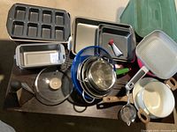 Wide shot showing all items piled including pots, strainers, graters, and bakeware.
