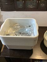 Stacked white square kitchen wash trays alongside rectangular glass mirrors with metallic handles