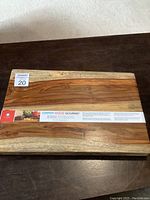 Top view of the rectangular Gripper Wood Gourmet cutting board showing its natural wood grain and label across the center.