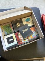 Photo showing a file box containing multiple jewel case CDs with visible album covers including 'Vitalogy'.