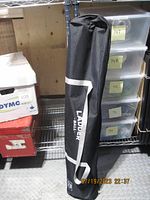 Photo of folded black carry bag with 'LADDER BALL' text visible.