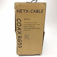 Photo of the cardboard box with product information showing 'NETX-CABLE COAX RG59' with specs such as UL listed, flame retardant PVC jacket, 1000 ft reele box, bare copper 20 AWG conductor, 1000 MHz frequency, 95% braided shielding, and details about no knots, kinks, or tangles.
