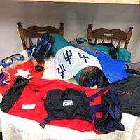 Full view of the outdoor gear laid out on table including canvas bag, snorkel, flippers, flags and inflatable mattress.