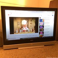 Samsung 56-inch TV turned on displaying a YouTube video showing a chef puppet cooking, demonstrating screen functionality and condition.