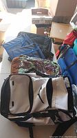 Photo of five bags laid out including Bugatti laptop bag, Hyundai carry bags, Roxy and Mizuno backpacks