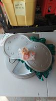 Top view of Petsafe automatic food dish partially covered by cat snuffle mat and plastic food mat with paw and fishbone decorations