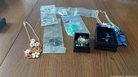 View of all jewelry sets arranged on table including necklace and earring sets and necklace and ring set