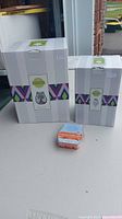 Photo of two boxed Scentsy wax warmers and a wax bar on a table