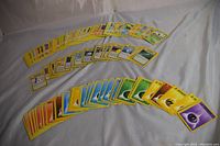 Multiple rows of vintage Pokemon cards laid out on a flat surface showing character cards, energy cards of various types, and some trainer cards.