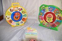 Two vintage talking pull toys on a white cloth, yellow Mattel Farmer Says (1983) and green Kermit Counts (1980), shown from a front angle.